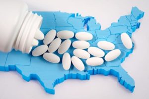 opioid pills spilling across a model of America