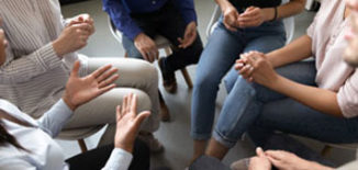 People sitting in a circle discussing evidence based treatment