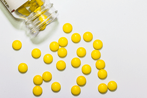 Yellow tablets spilled onto an off-white surface