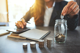 Woman taking notes with stacks of quarters on her desk