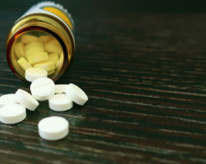 Addictive pills spilling out of a pill bottle
