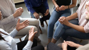 People sitting in a circle discussing evidence based treatment