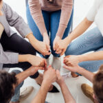 top view of people holding hands during group therapy session