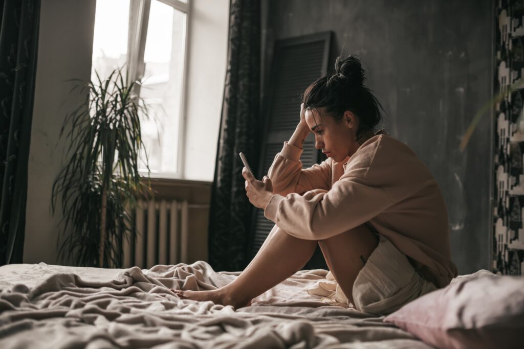 sad girl with brown hair looking at her social media accounts