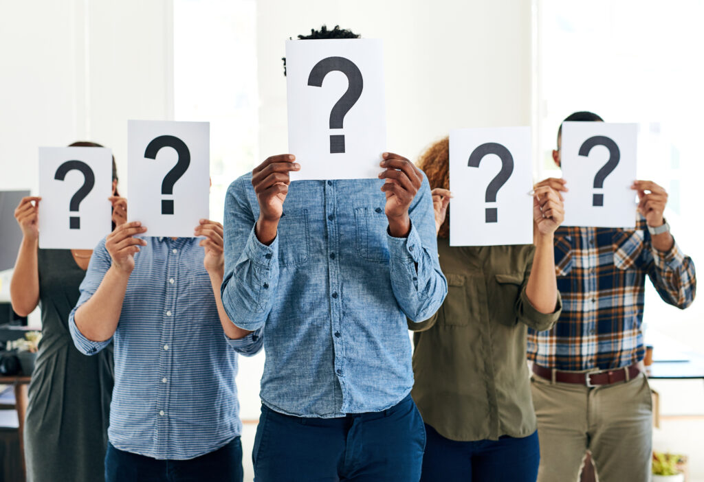 people holding a paper with a question mark on it to signify confusion