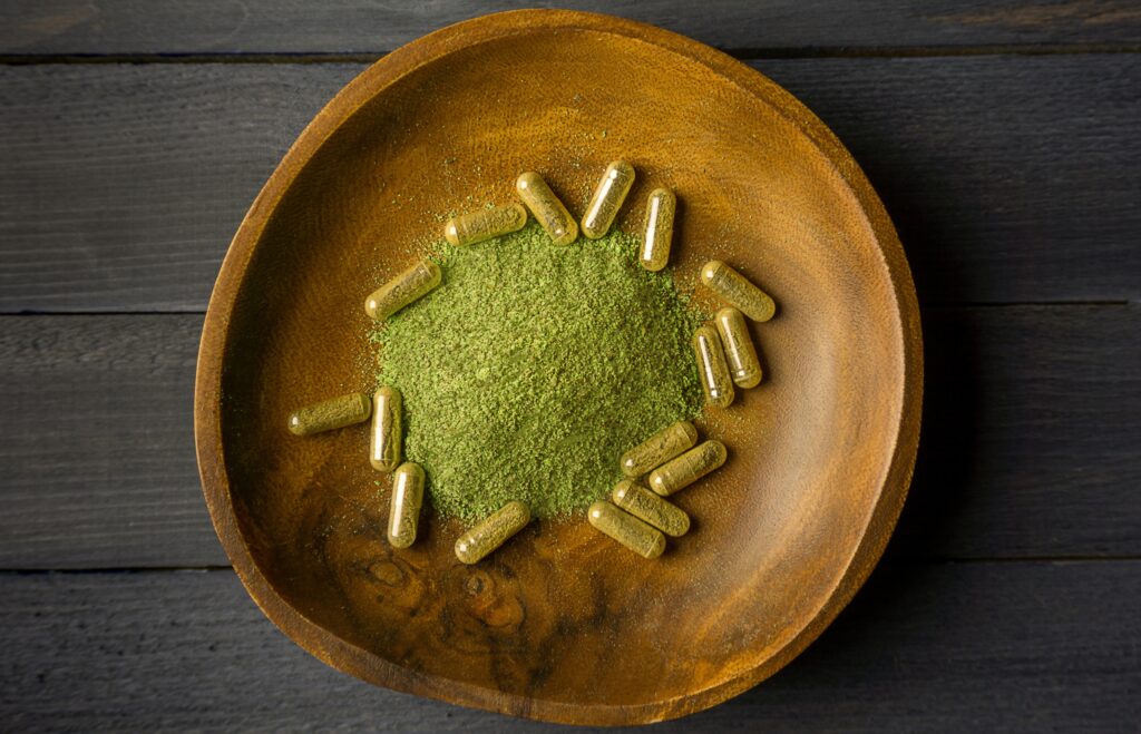 kratom-powder-and-capsules-in-wooden-bowl-2025-01-09-07-57-55-utc