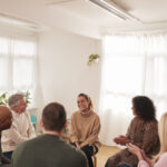 Woman Speaking At Support Group Meeting For Mental Health Or Dependency Issues In Community Space