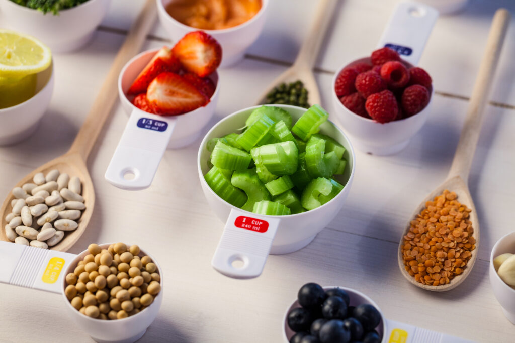 Portion cups of healthy ingredients on wooden table