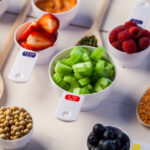 Portion cups of healthy ingredients on wooden table