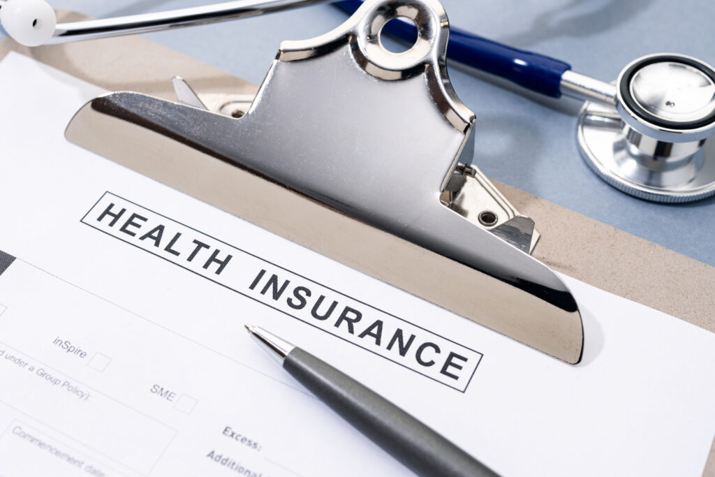 Health Insurance form and stethoscope on desk. No people
