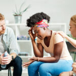 Group psychotherapy. Persons sitting in circle and talking. People meeting. Psychotherapy training, business lecture or conference. Man woman support group
