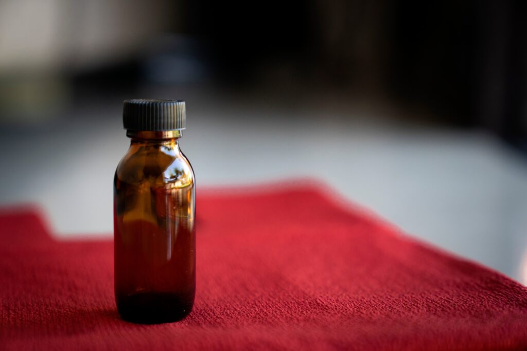 amber-glass-bottle-on-red-background-2025-03-10-12-19-55-utc