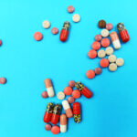 A top view of medical pills and capsules isolated on a blue background, Medical concept of treatment diseases