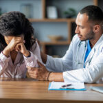 Attentive handsome arabic man doctor supporting sad black woman patient, upset african american lady