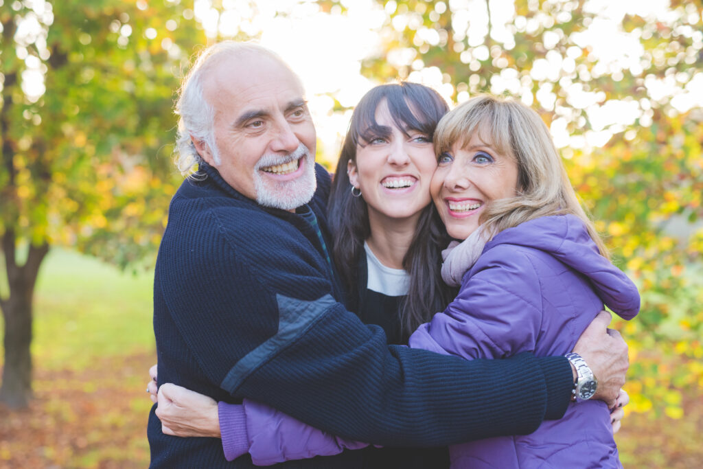 Happy family smiling hugging outdoors