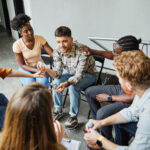 Group psychotherapy. Persons sitting in circle and talking. People meeting. Psychotherapy training, business lecture or conference. Man woman support group